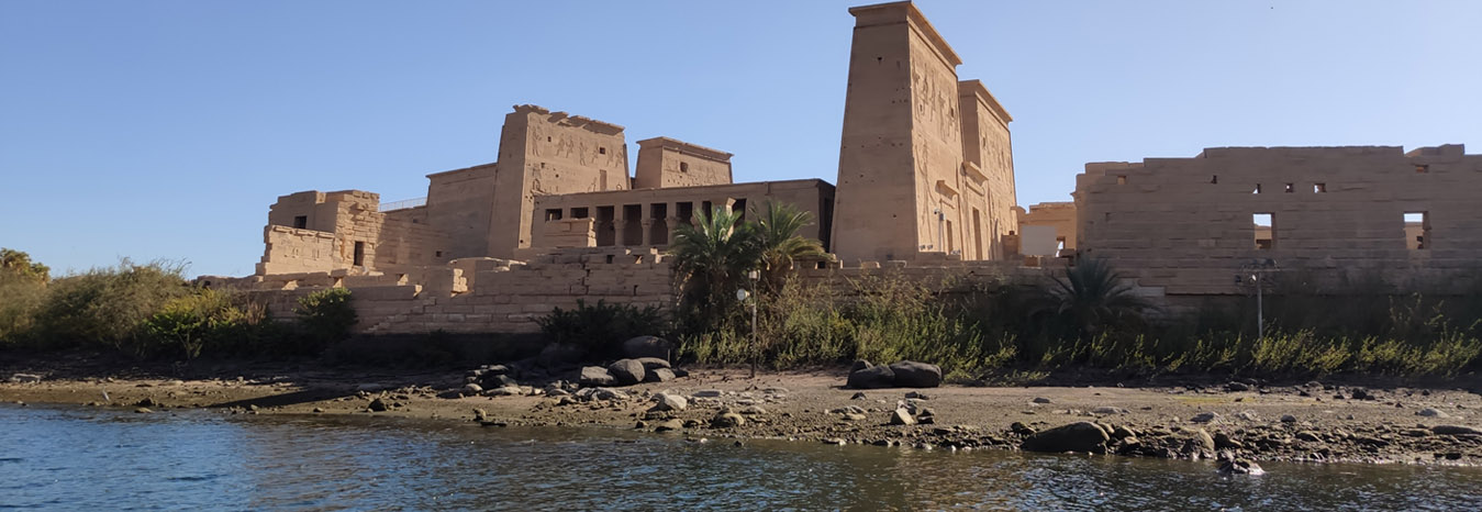 The majestic pylons of Philae Temple reflected in the waters of the Nile at Aswan.