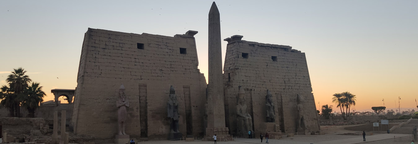 The grand entrance pylon and colossal statues of Ramses II at Luxor Temple.