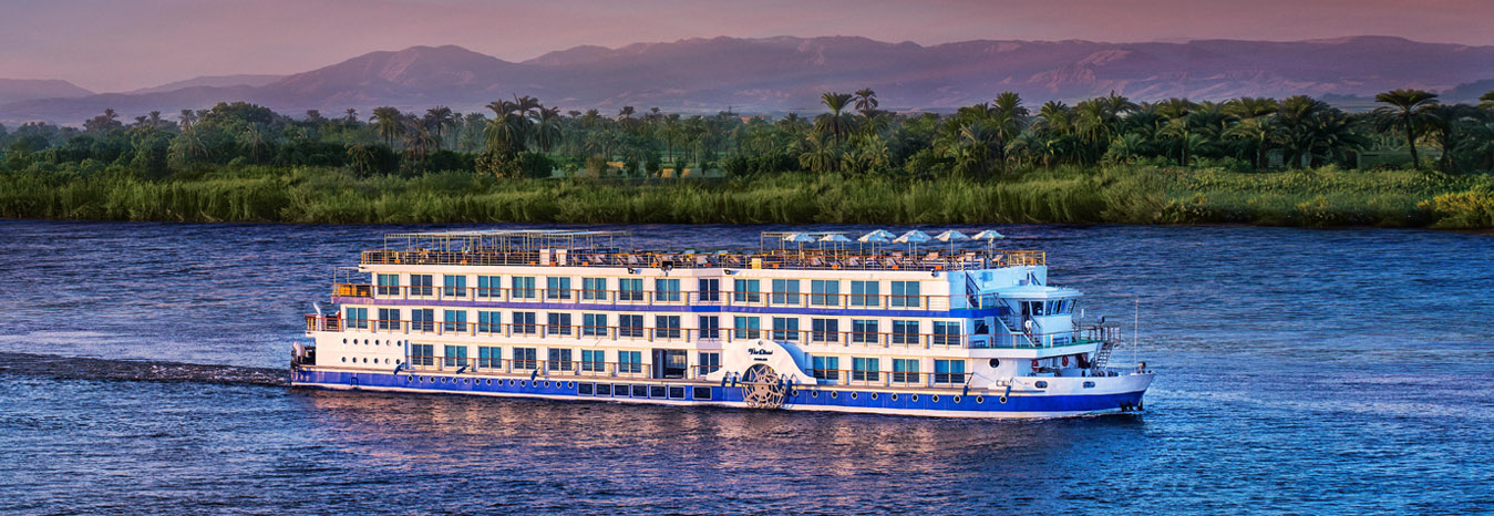 The Oberoi Philae Luxury Nile Cruise sailing on the Nile River under a clear blue sky.