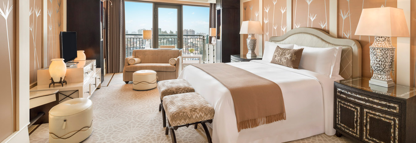 Spacious and elegant luxury bedroom at the St. Regis Cairo Hotel with floor-to-ceiling windows overlooking the Nile.