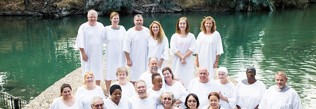 Catholic pilgrims at the Jordan River baptism site during 8 days Holy Land pilgrimage