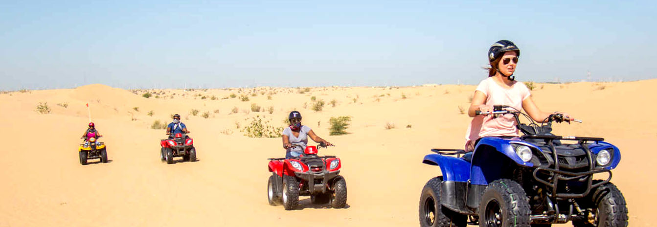 Travelers riding quad bikes through the golden desert dunes of Hurghada during sunset.