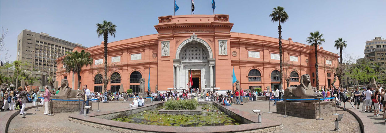 The neoclassical red facade of the Egyptian Museum in Cairo, housing the world's largest collection of pharaonic artifacts.