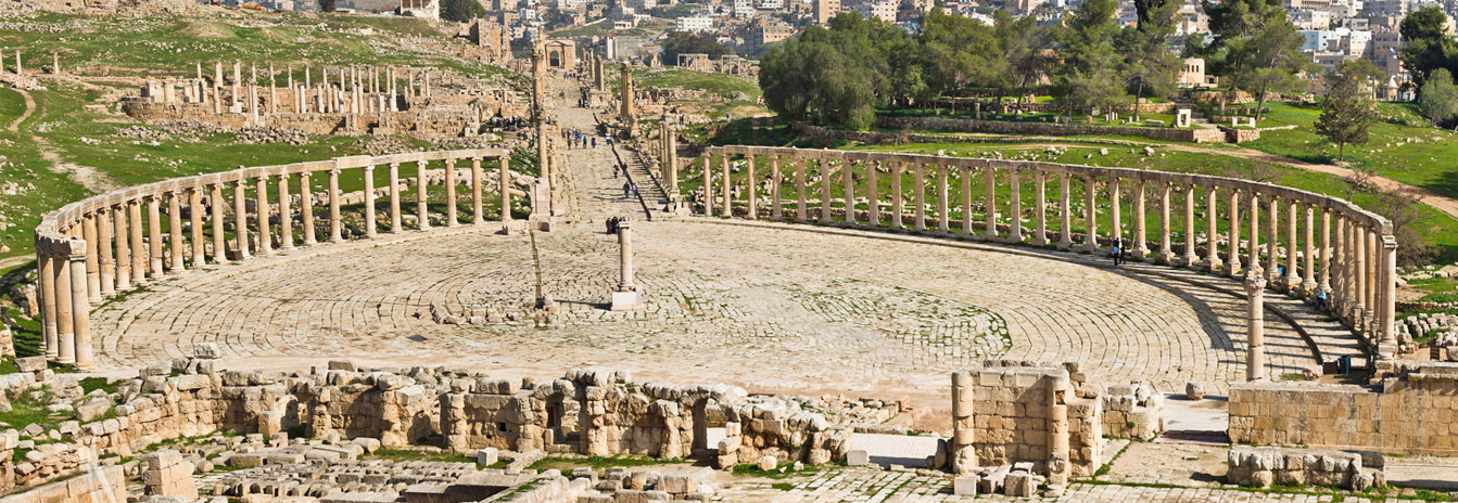 The ancient Roman ruins of Jerash in Jordan featuring the monumental Arch of Hadrian and colonnaded streets.