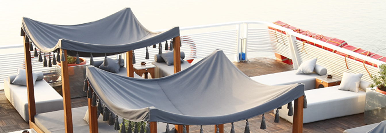The expansive sun deck of the MS Darakum with a swimming pool and shaded cabanas.