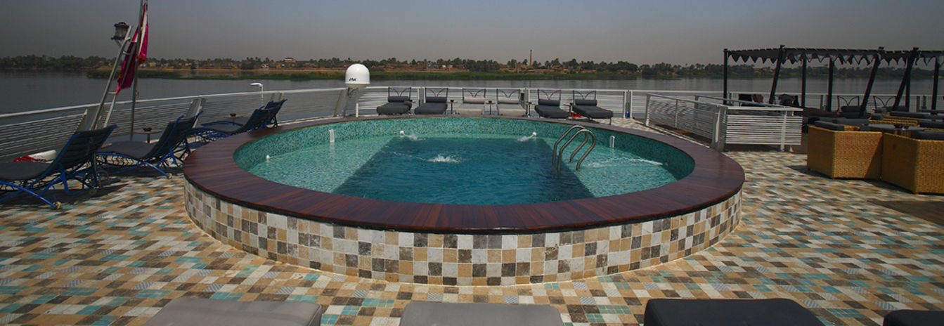 The upper deck of the MS Darakum featuring a swimming pool, Moroccan cabanas, and views of the Nile banks.