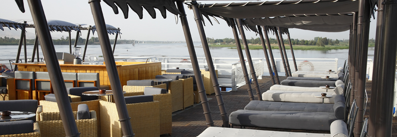 The upper sun deck of the MS Darakum with a swimming pool and Moroccan-style shaded lounge chairs.