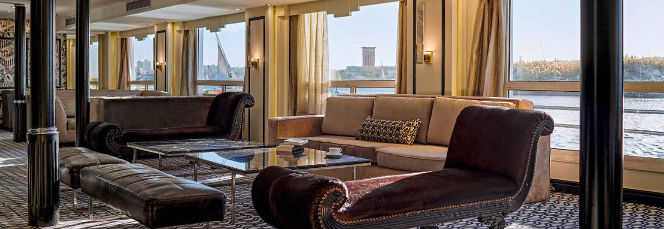 The spacious panoramic lounge on the MS Hamees with floor-to-ceiling windows and comfortable seating.