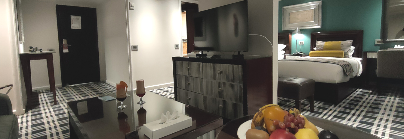 A spacious luxury suite on the Mövenpick MS Sunray with large windows and contemporary Swiss decor.