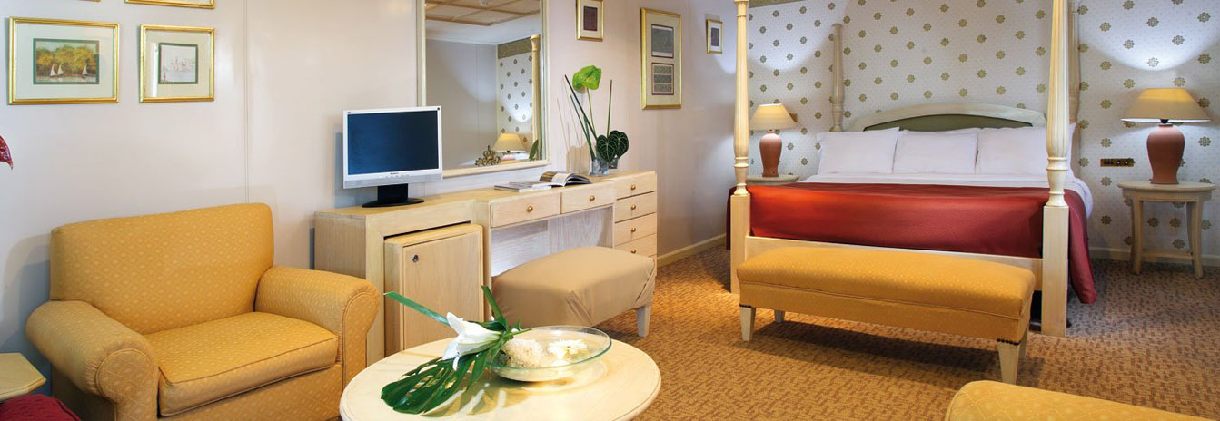 Contemporary luxury cabin on a Mövenpick Nile Cruise with large windows and elegant wood finishes.