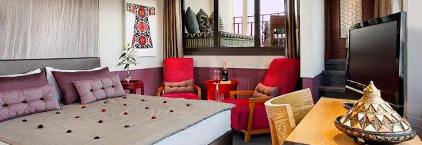 A spacious and modern suite on the Mövenpick SB Feddya with a large panoramic window and contemporary decor.