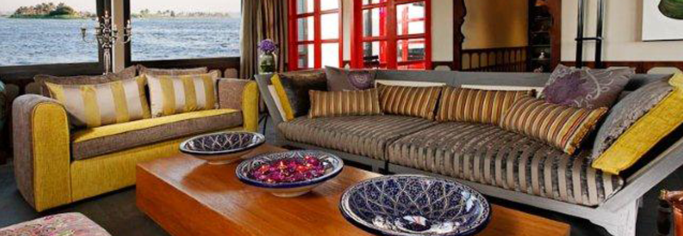 The luxury lounge of the Mövenpick SB Feddya boutique Dahabiya featuring contemporary designer sofas and Nile views.