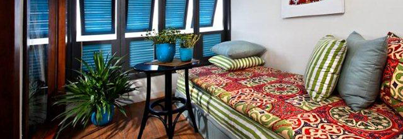 Cozy window seating area on the Mövenpick SB Feddya boutique vessel with colorful cushions and blue shutters.
