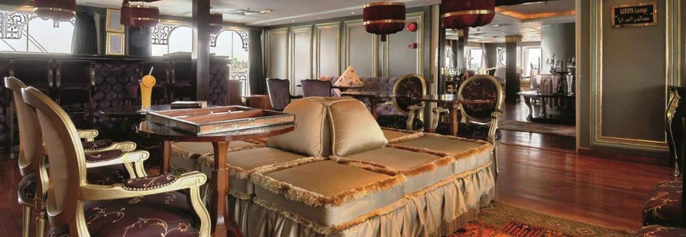 The Marasem Restaurant on the SS Misr with elegant table settings and historic royal portraits.