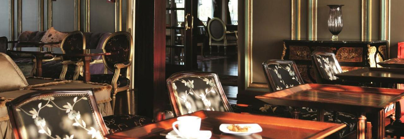 The elegant Saraya Lounge on the SS Misr with velvet seating and vintage wood-paneled décor.
