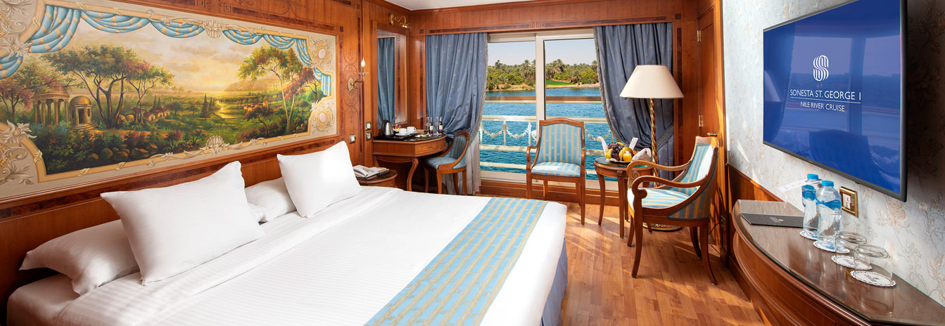 Sophisticated Deluxe Cabin on Sonesta St. George Nile Cruise featuring a French balcony and panoramic Nile views.