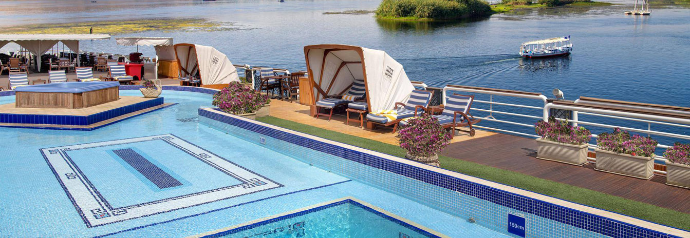 Spacious sun deck of the Sonesta St. George Nile Cruise with an oversized swimming pool and outdoor lounge.