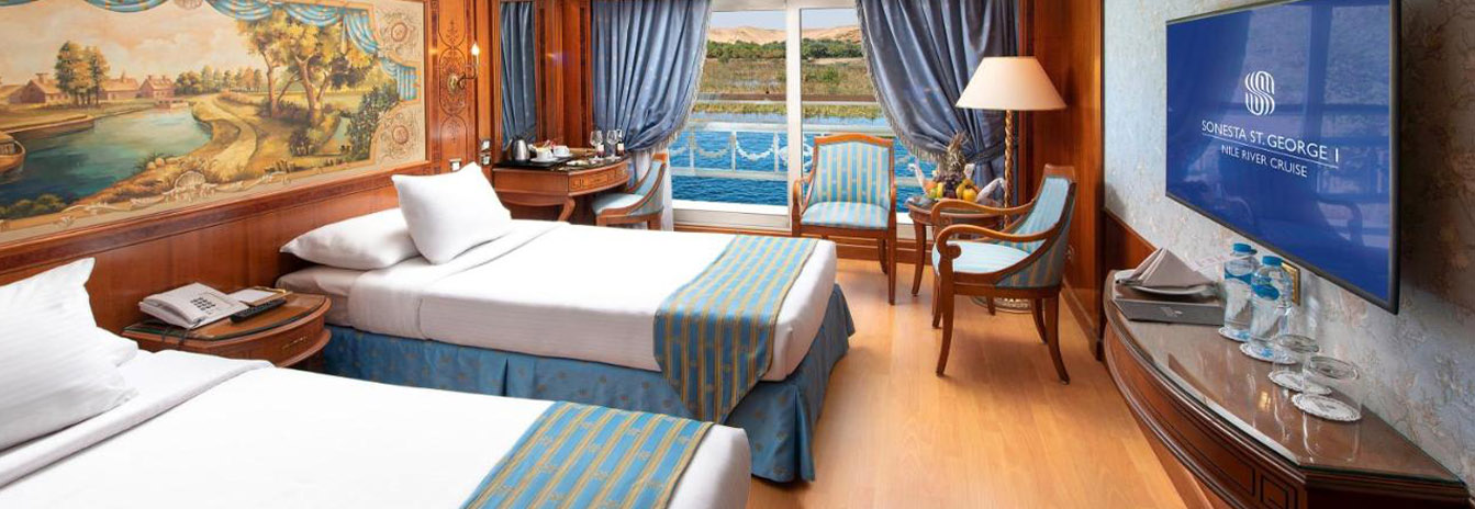 Sophisticated Deluxe Cabin on Sonesta St. George Nile Cruise featuring a French balcony and panoramic Nile views.