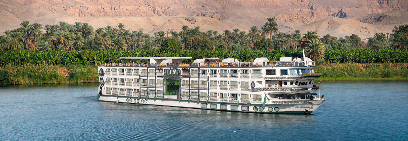 Luxury Sonesta St. George I Nile Cruise ship with French-style architecture sailing near Aswan, Egypt.